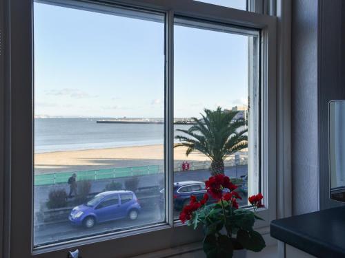 a room with a window with a view of the beach at Seagulls Lookout in Weymouth