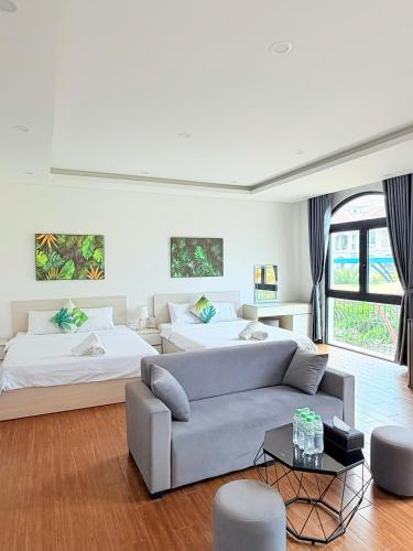 a living room with two beds and a couch at Tropical Bay Villas and Homestay in Phú Quốc