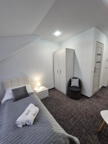 a bedroom with a bed with two towels on it at Villa Sovita in Łeba