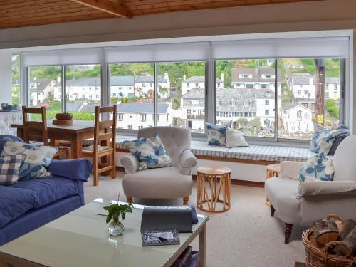 a living room with couches and a large window at Topsail in Newton Ferrers