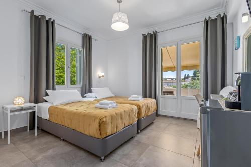a bedroom with a large bed in a room with windows at Kamelia Hotel in Spetses