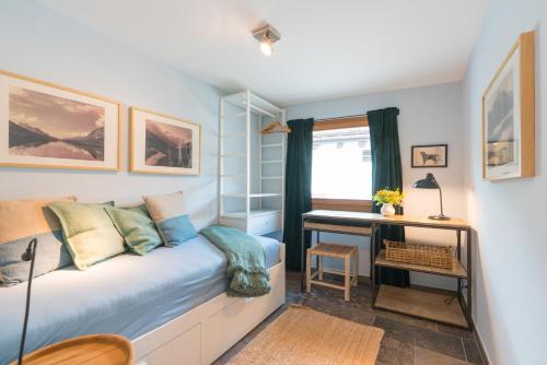 a small room with a bed and a desk at Chesa Survial 4 in Sils Maria