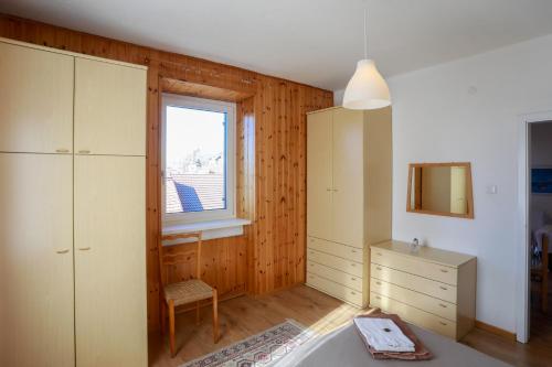 a bedroom with a bed and a dresser and a window at ANESI appartamenti in Baselga di Pinè