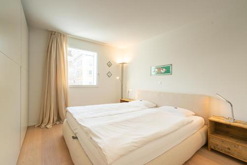a bedroom with a large bed and a window at Residenza Edelweiss 5 3 in Sils Maria