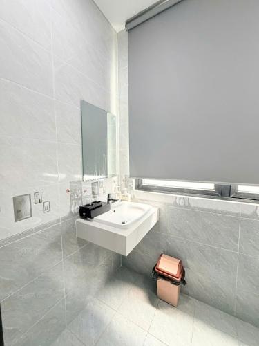 a white bathroom with a sink and a mirror at Tropical Bay Villas and Homestay in Phú Quốc