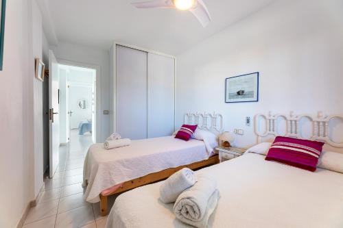 a white room with two beds and a bathroom at Apartamento Veleta Puerto Pollensa in Pollença