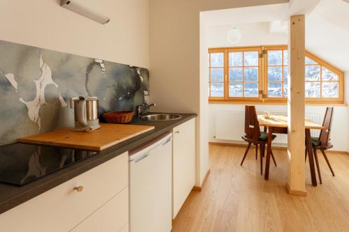 a kitchen with a sink and a wooden table at Pension Hallberg in Hallstatt