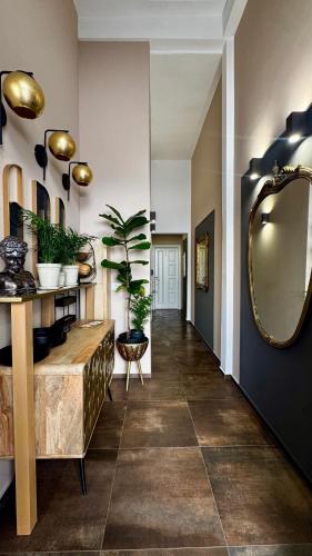 a hallway with a mirror and plants on the wall at TERA house&rooms in Reggio di Calabria