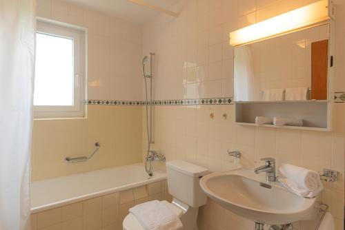 a bathroom with a sink and a toilet and a tub at Chesa Tscheppa 1 in Sils Baselgia
