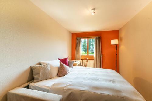 a large bed in a room with orange walls at Chesa Tscheppa 1 in Sils Baselgia