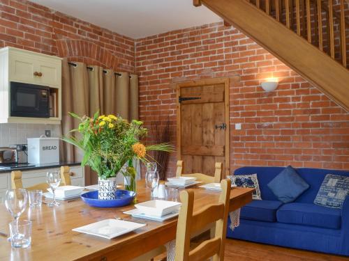 a dining room with a table and a blue couch at The Stables in Eardisland