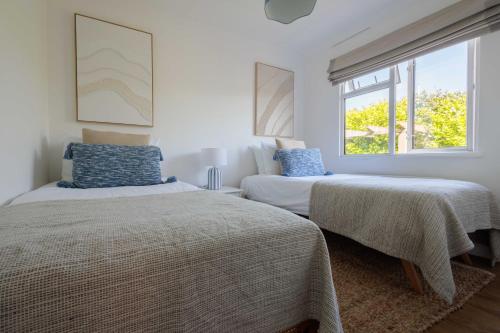 a bedroom with two beds and a window at Hot Tub With A View - Christchurch Harbour in Christchurch