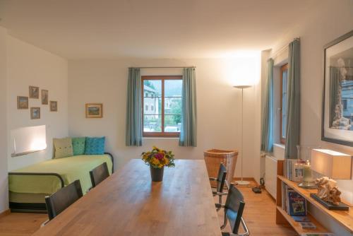 a living room with a table and a bedroom at Chesa Clos in Sils Baselgia