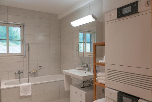 a bathroom with a sink and a bath tub and a sink at Chesa Clos in Sils Baselgia