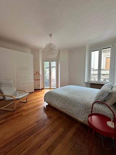 a bedroom with a bed and a chair and a chandelier at L'Angolo di Mede in Mede