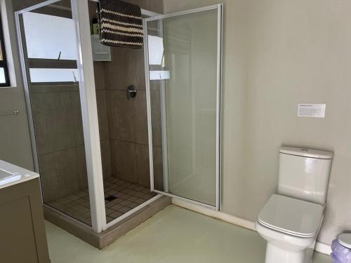 a shower stall in a bathroom with a toilet at Fever Tree B&B in Gonubie Manor