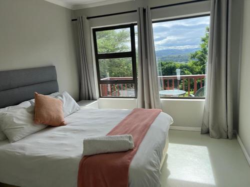 a bedroom with a bed and a large window at Fever Tree B&B in Gonubie Manor