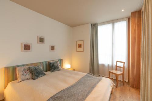 a bedroom with a large bed and a window at Chesa Piol in Maloja
