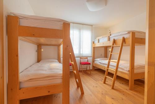 a bedroom with two bunk beds and a desk at Chesa Blaunca B4 in Maloja