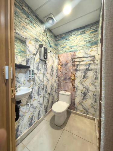 a bathroom with a toilet and a sink at Tang Hotel in Alor Setar