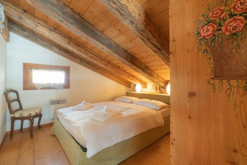 a bedroom with a bed in a room with wooden ceilings at Chesa Cavril in Maloja