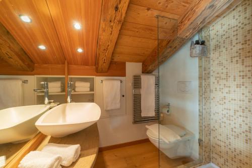 a bathroom with a white sink and a toilet at Chesa Cavril in Maloja