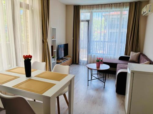 a living room with a couch and a table at Green apartments in Primorsko