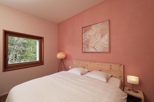a bedroom with a white bed and a window at Chesa Soldanella 9 in Maloja