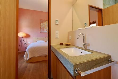 a bathroom with a sink next to a bedroom at Chesa Soldanella 9 in Maloja