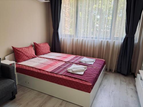 a bedroom with a bed with two dishes on it at Green apartments in Primorsko