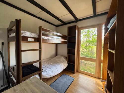 a dorm room with bunk beds and a window at LES COTTAGES DE LEON in Léon