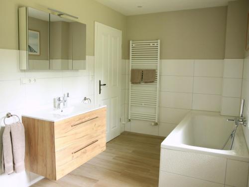 a bathroom with a tub and a sink and a bath tub at Hof Muhs in Stakendorf