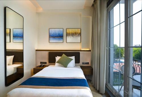 a hotel room with a bed and a large window at Basilica Resort, Lonavala in Lonavala