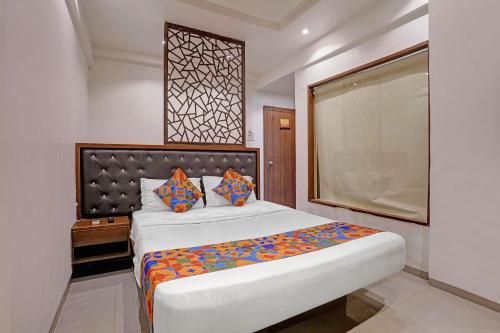 a bedroom with a large bed and a large window at FabHotel Dukes Plaza in Ulhāsnagar