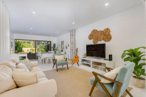 a living room with a white couch and a tv at Morada do Sol with Private Pool & Garden in Alvor