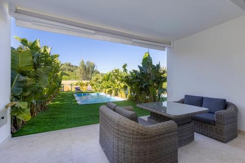 a living room with a patio with a table and chairs at Morada do Sol with Private Pool & Garden in Alvor