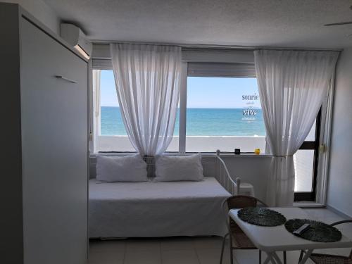 a bedroom with a bed and a view of the ocean at Apartahotel Estudio 221 in Matalascañas