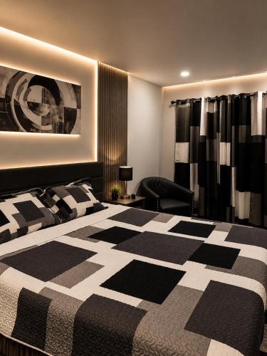 a bedroom with a black and white bed and a chair at Lake George Residence LLC in South Glens Falls