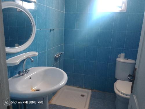 a blue tiled bathroom with a sink and a toilet at villa Flori Midoun in Djerba