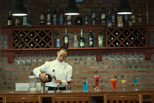 a chef standing behind a bar preparing a drink at Inle Cottage Boutique Hotel in Nyaung Shwe