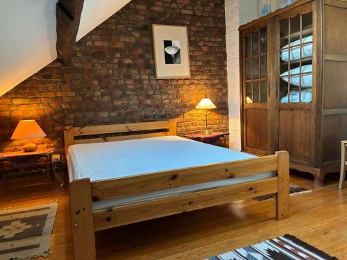 a bedroom with a bed and a brick wall at La Vigne - Han-sur-Lesse in Han-sur-Lesse