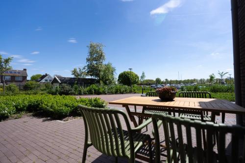 a wooden table and chairs sitting on a patio at Oan 'e Haven in Oudega