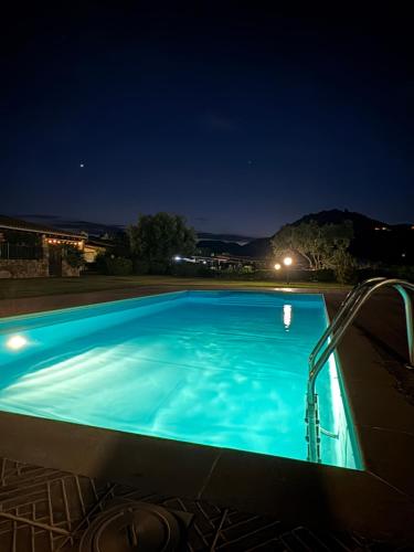 a large blue swimming pool at night at Villino Giò - Residence Abba Urci in Tertenìa