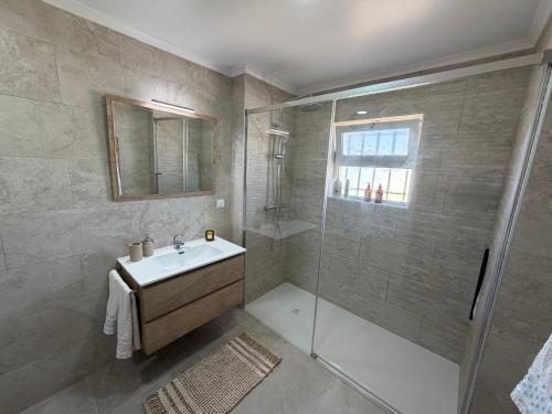 a bathroom with a shower and a sink and a glass shower stall at Villa Balsa in Tavira