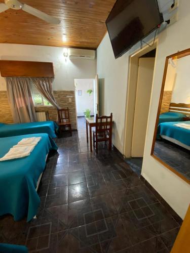 ein Zimmer mit zwei Betten, einem Tisch und Stühlen in der Unterkunft Dennisse Hotel in Victoria