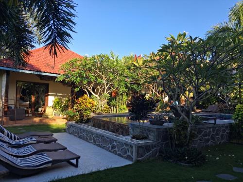 a resort yard with lounge chairs and a pool at Ombak Resort at Ekas , a luxury surf and kite destination, Close to Inside Ekas beach in Ekas