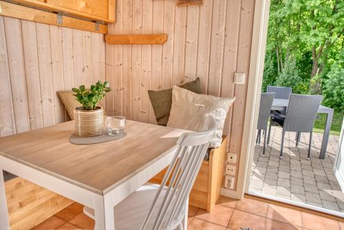 a table and chairs in a room with a patio at Apelvikens Camping & Cottages in Varberg