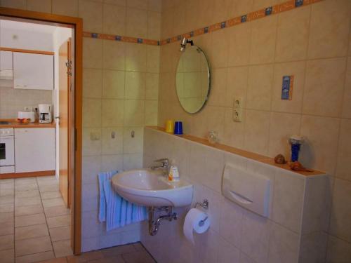 a bathroom with a sink and a mirror at Ferienwohnung Meyer in Schönwald