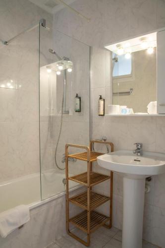 a white bathroom with a sink and a shower at Hostal La Llagosta in Llafranc