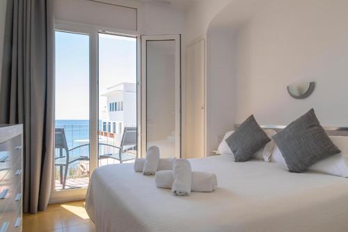 a bedroom with a bed with a view of the ocean at Hostal La Llagosta in Llafranc
